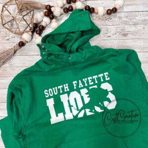 Kelly green hooded sweatshirt with white text. South Fayette over LIONS. Image of a lion is knocked out of the word lion for an artistic effect.